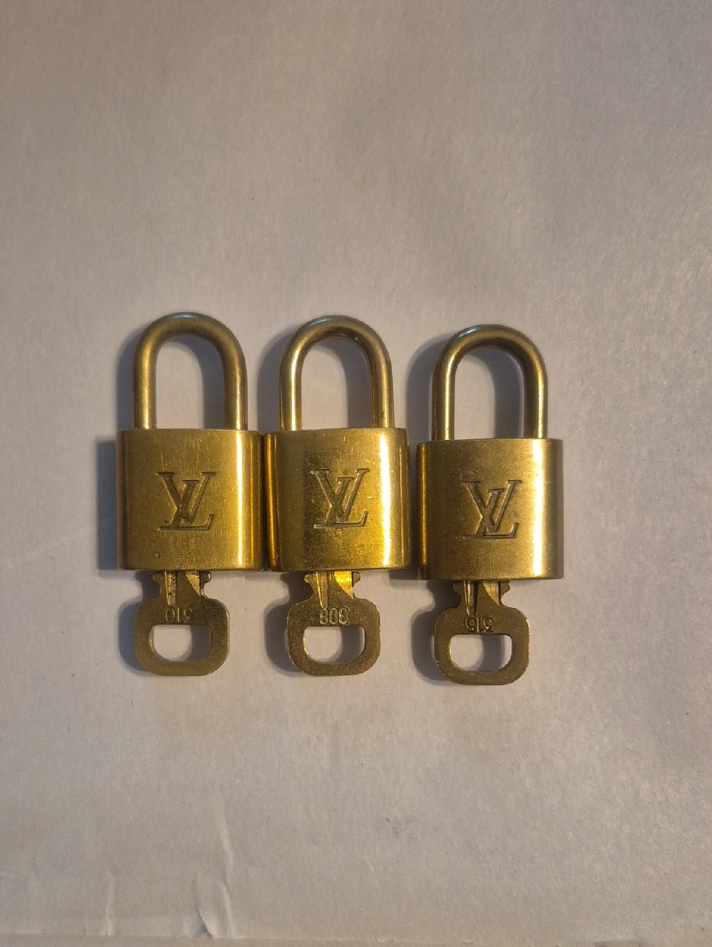 Authentic.Louis Vuitton Gold LV Padlocks Set of Three